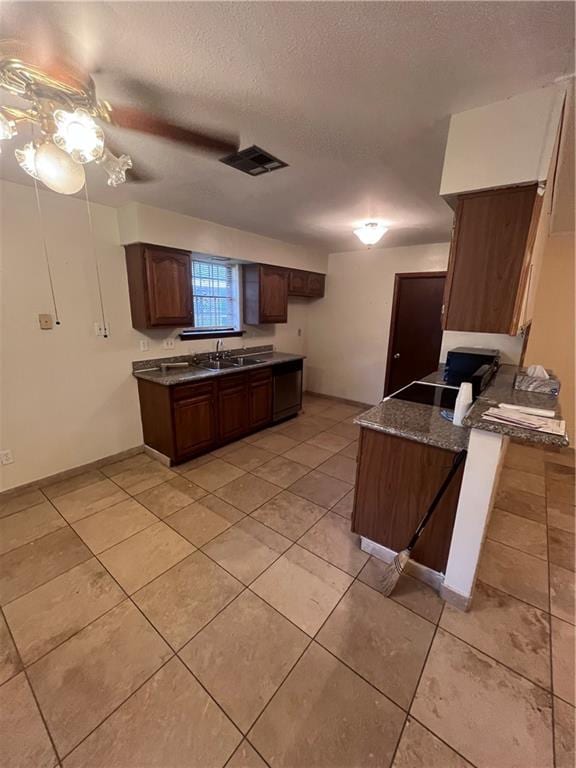 kitchen with black stove, dark brown cabinets, sink, a textured ceiling, and ceiling fan