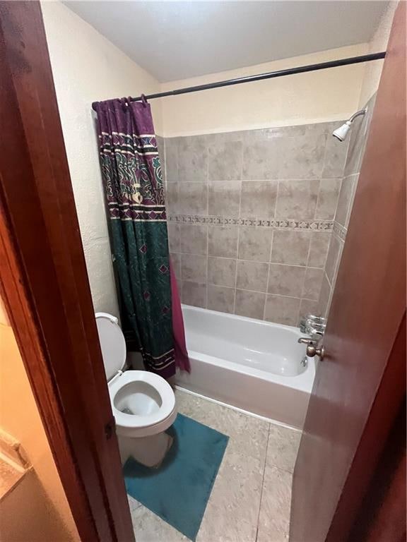 bathroom featuring shower / bath combination with curtain, toilet, and tile patterned flooring