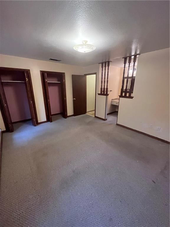 unfurnished bedroom with a textured ceiling and carpet