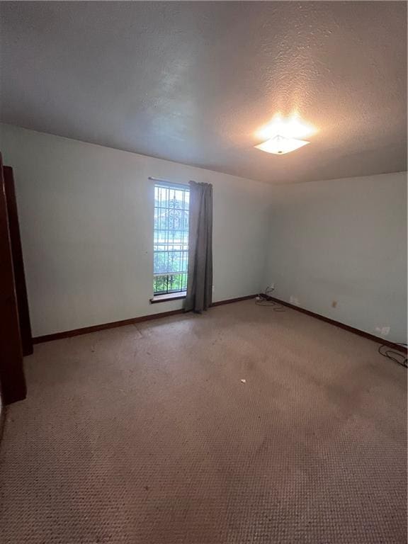 carpeted empty room featuring a textured ceiling