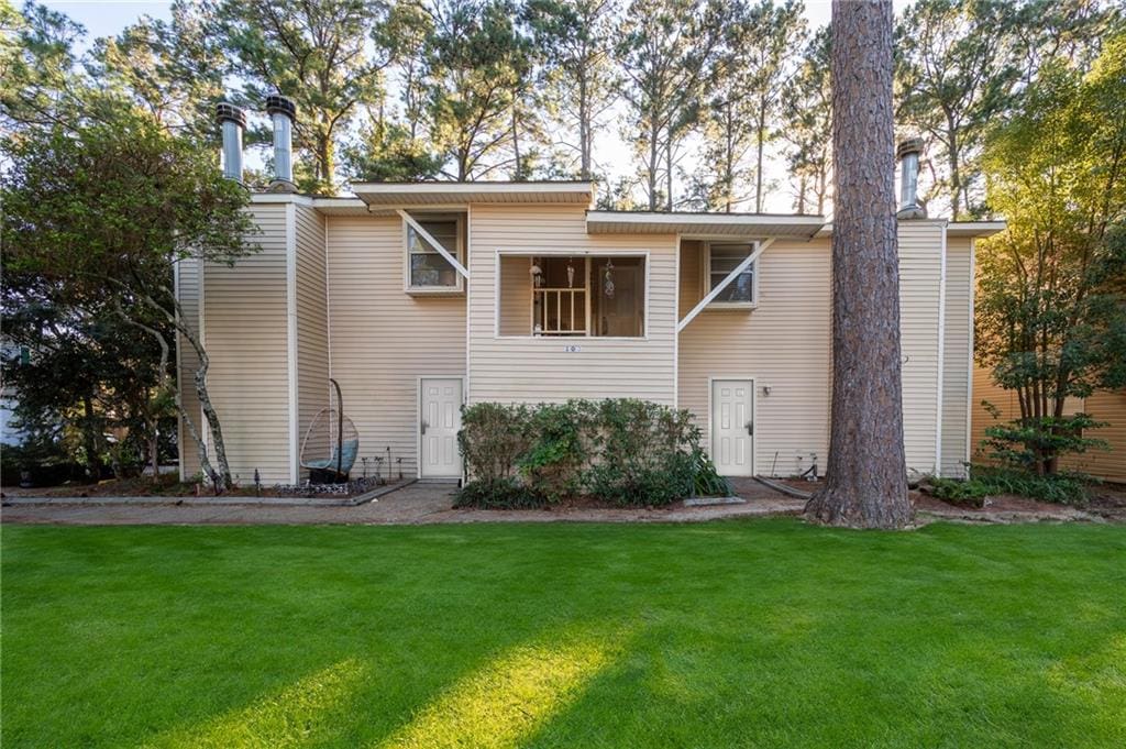 rear view of house featuring a lawn