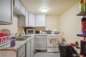 kitchen featuring gray cabinetry and white stove