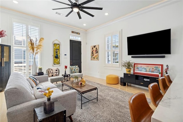 living room with ceiling fan, ornamental molding, wood-type flooring, and plenty of natural light