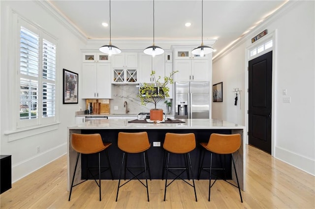 kitchen featuring stainless steel fridge with ice dispenser, plenty of natural light, and hanging light fixtures