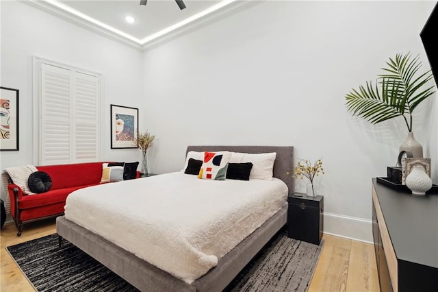 bedroom featuring crown molding, wood-type flooring, and ceiling fan