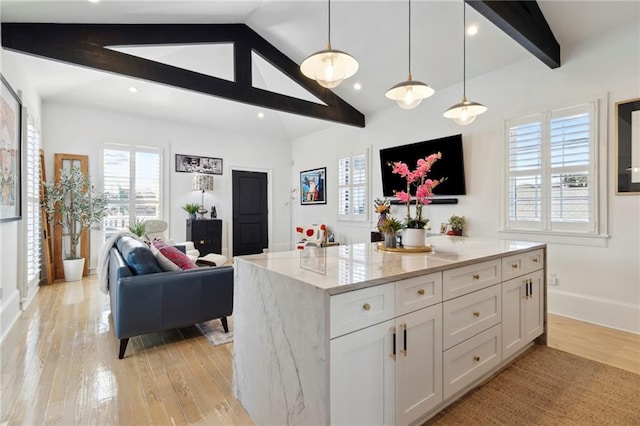 kitchen featuring vaulted ceiling with beams, hanging light fixtures, light stone countertops, white cabinetry, and light hardwood / wood-style floors