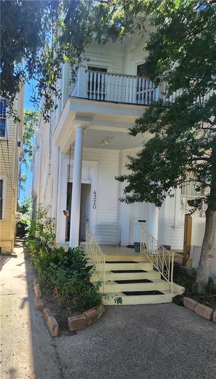 view of exterior entry featuring a balcony