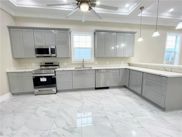 kitchen featuring stainless steel appliances, sink, kitchen peninsula, gray cabinets, and pendant lighting