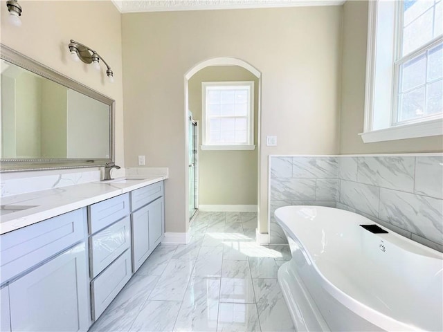 bathroom with tile walls, vanity, and independent shower and bath