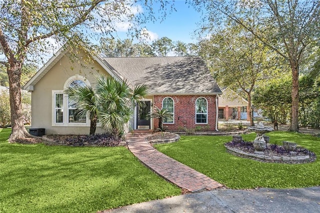 246 Cypress St, Independence, LA 70443 - view of front of house with stucco siding, brick siding, cooling unit, and a front lawn