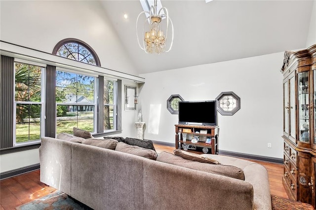 living room featuring hardwood / wood-style flooring, high vaulted ceiling, and an inviting chandelier