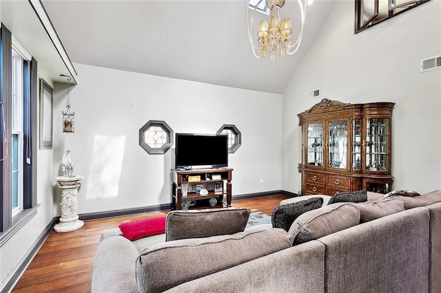 246 Cypress St, Independence, LA 70443 - living room with baseboards, high vaulted ceiling, an inviting chandelier, and wood finished floors