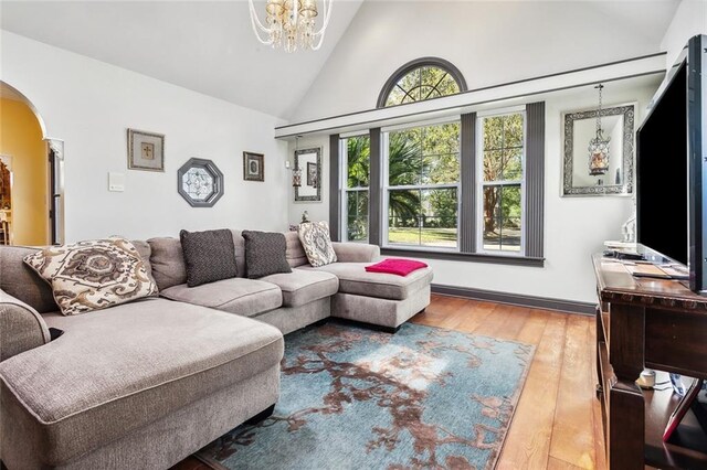 living room with a chandelier, hardwood / wood-style flooring, and high vaulted ceiling