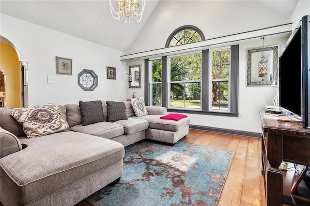 246 Cypress St, Independence, LA 70443 - living room featuring arched walkways, wood finished floors, a notable chandelier, and high vaulted ceiling