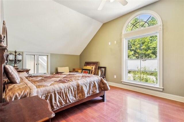 bedroom with ceiling fan, multiple windows, wood-type flooring, and lofted ceiling