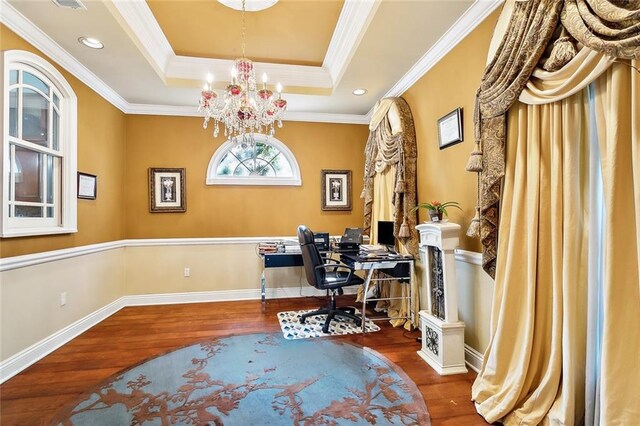 home office with crown molding, hardwood / wood-style flooring, a tray ceiling, and a notable chandelier