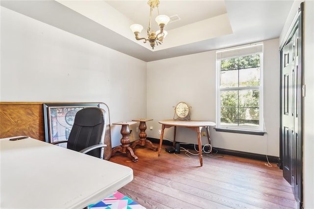 246 Cypress St, Independence, LA 70443 - home office featuring an inviting chandelier, wood-type flooring, visible vents, baseboards, and a tray ceiling