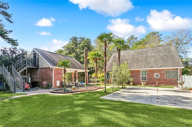 246 Cypress St, Independence, LA 70443 - exterior space with a lawn, brick siding, stairway, and a patio area