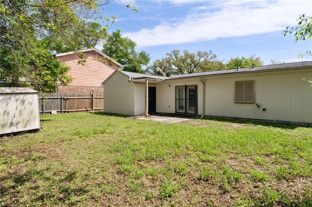 rear view of house with a patio, a storage unit, and a lawn