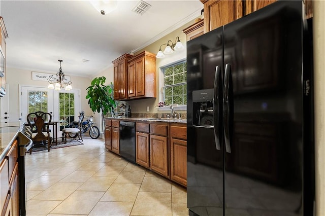 kitchen with french doors, black appliances, light tile patterned floors, decorative light fixtures, and a notable chandelier