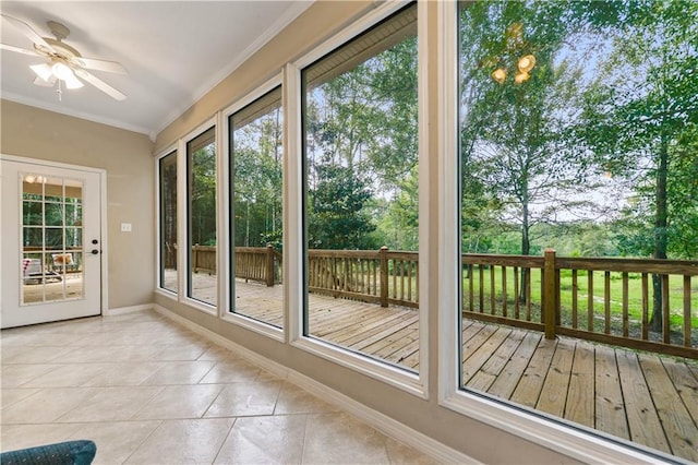 doorway featuring light tile patterned floors, ceiling fan, and ornamental molding