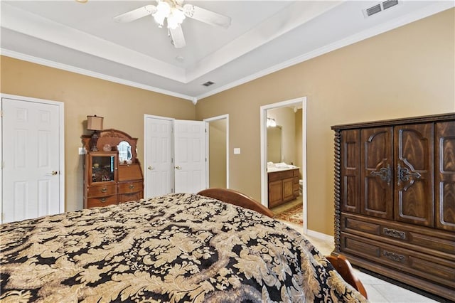 tiled bedroom featuring a raised ceiling, ensuite bath, ceiling fan, and ornamental molding