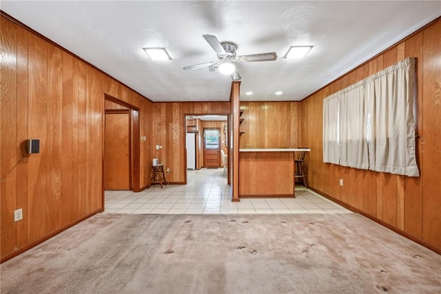 kitchen with wood walls, ceiling fan, light colored carpet, and white refrigerator