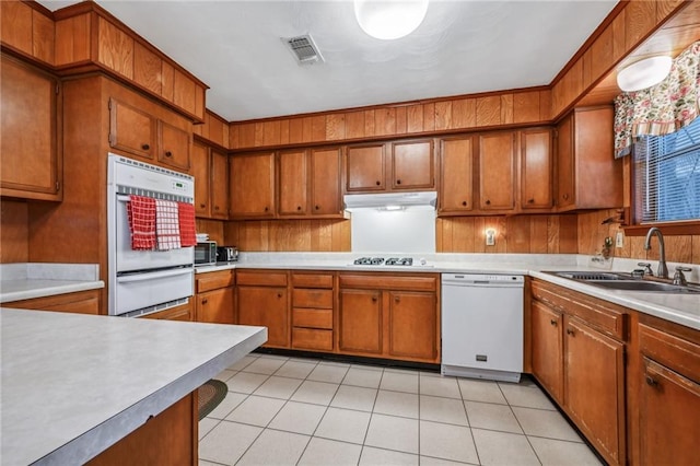 kitchen featuring light tile patterned flooring, sink, and white appliances