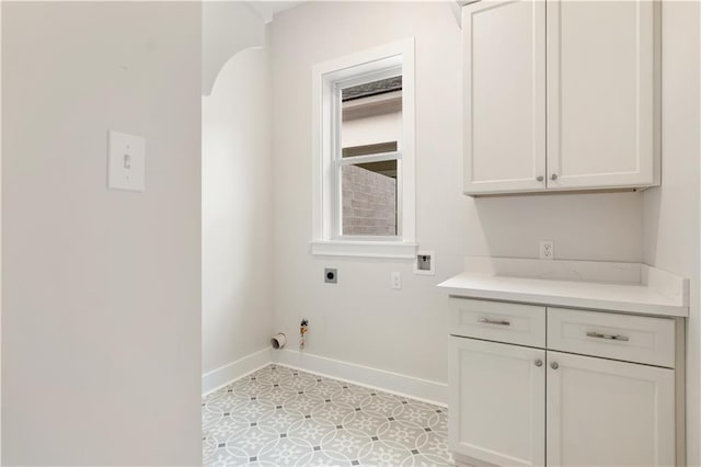 laundry room featuring hookup for a gas dryer, light tile patterned flooring, cabinets, and electric dryer hookup