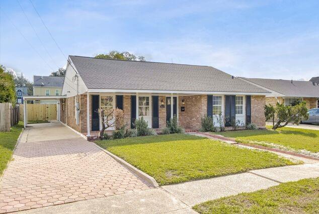 ranch-style house with a front yard and a carport