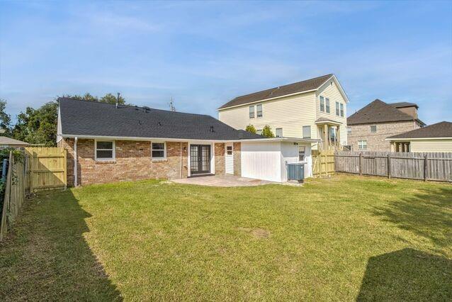 rear view of house featuring a patio, a yard, and central AC unit