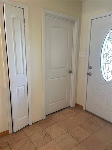 entrance foyer featuring light tile patterned floors and baseboards