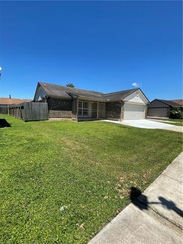 ranch-style home featuring a garage, brick siding, fence, concrete driveway, and a front lawn