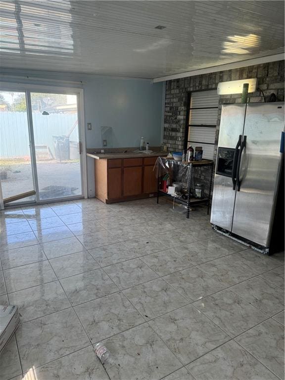 kitchen with sink, crown molding, and stainless steel refrigerator with ice dispenser