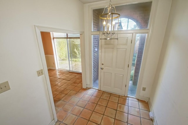 tiled entryway featuring an inviting chandelier