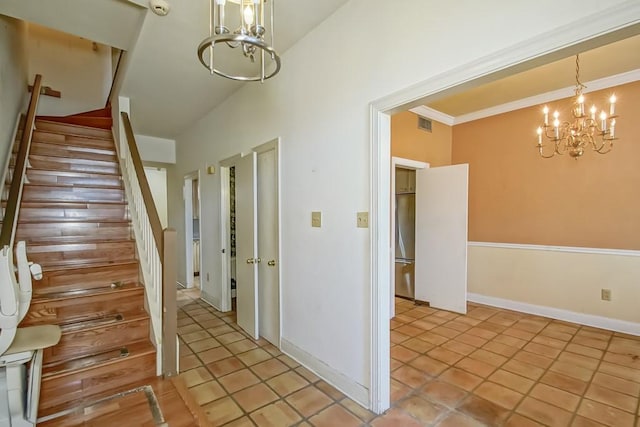 staircase featuring ornamental molding, a chandelier, and tile patterned flooring