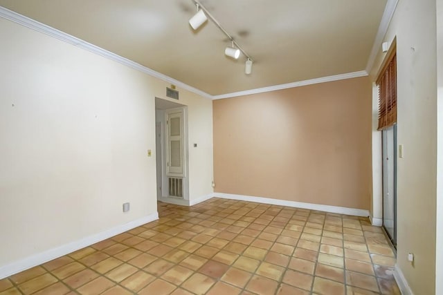 empty room with ornamental molding, light tile patterned flooring, and rail lighting