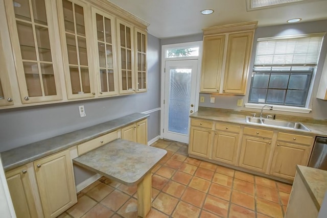 kitchen with light tile patterned flooring, sink, light brown cabinets, and dishwasher