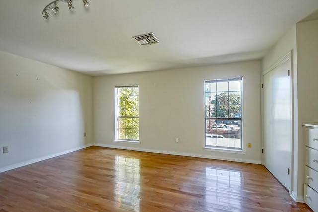 spare room featuring light hardwood / wood-style flooring and a healthy amount of sunlight