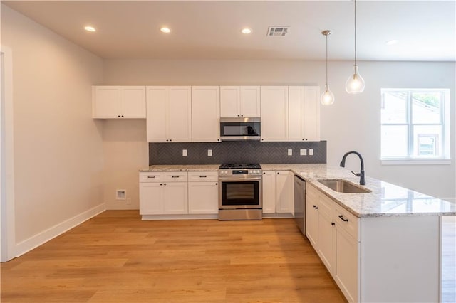 5144 Richland Ave, Marrero, LA 70072 - kitchen featuring a sink, stainless steel appliances, a peninsula, decorative backsplash, and light wood-style flooring