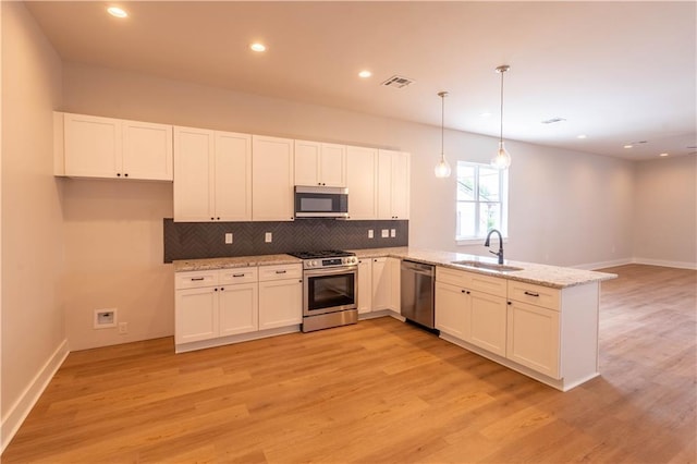 5144 Richland Ave, Marrero, LA 70072 - kitchen with stainless steel appliances, a sink, a peninsula, tasteful backsplash, and light wood-style floors