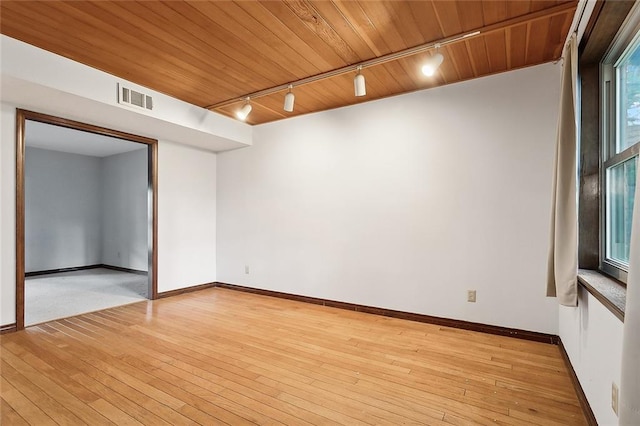 unfurnished room with wood ceiling, track lighting, and light wood-type flooring