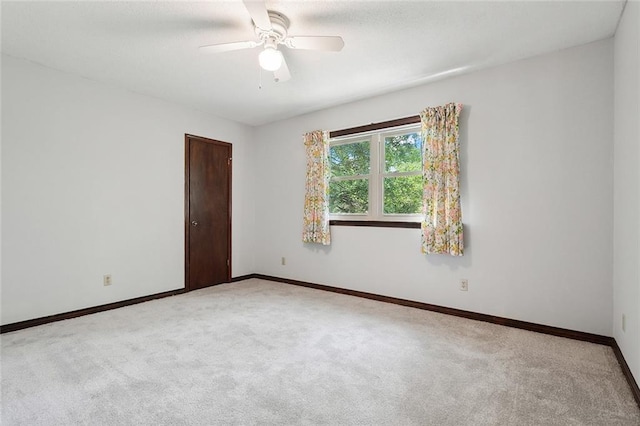 spare room featuring ceiling fan and carpet