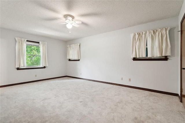 spare room featuring ceiling fan, a textured ceiling, and light colored carpet