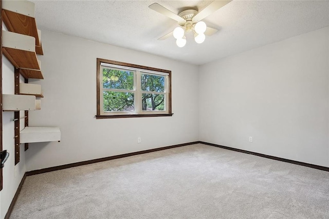 unfurnished room with a textured ceiling, light colored carpet, and ceiling fan