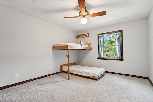 unfurnished bedroom with light carpet, a textured ceiling, and ceiling fan