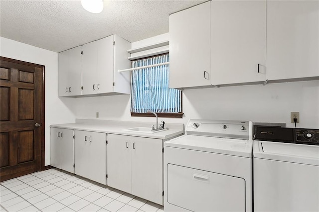 laundry room featuring sink, light tile patterned flooring, separate washer and dryer, cabinets, and a textured ceiling