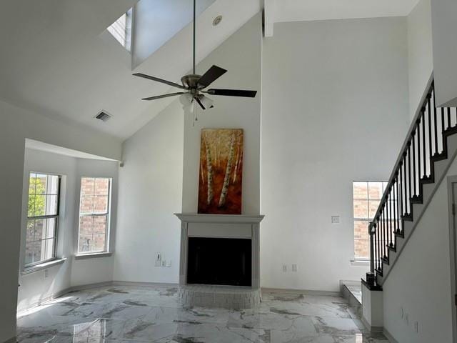 unfurnished living room with ceiling fan and high vaulted ceiling