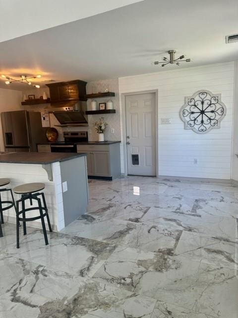 kitchen with a kitchen bar, electric range oven, and range hood