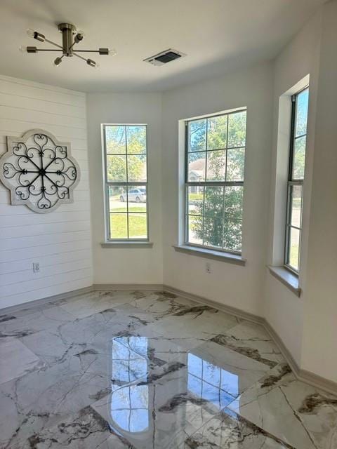 unfurnished room with an inviting chandelier